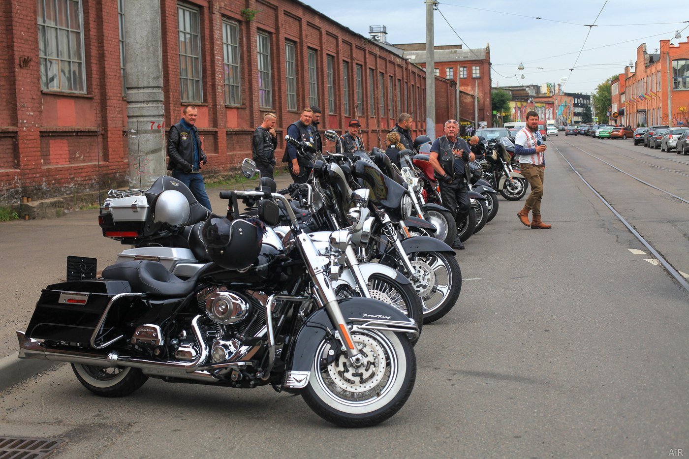 Шеренга Harley-Davidson на фоне кирпичной архитектуры